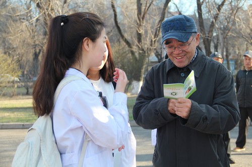 志愿者向社区居民发放健康知识手册