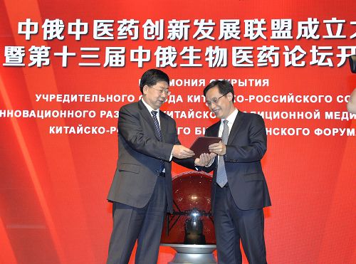 黑龙江省政协副主席杜吉明(左)为中俄中医药创新发展联盟首届主席黄璐琦院士颁发聘书