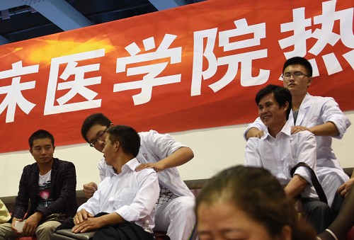 学生志愿者为休息区的家长提供按摩推拿服务,舒缓他们的疲劳