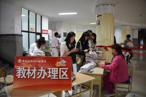 工作人员为新同学发放教材