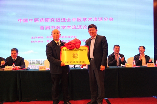黑龙江省卫生和计划生育委员会副主任邢济春(右)为黑龙江省龙江医派研究中心授牌