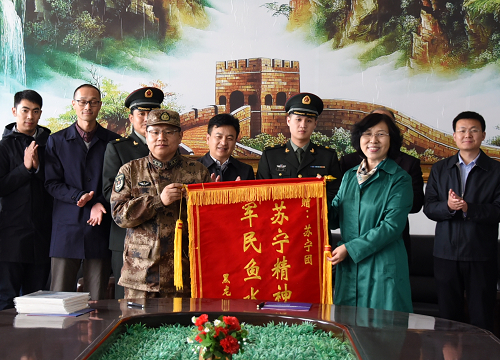校党委副书记代表学校向部队赠送书有“苏宁精神永存 军民鱼水情深”的锦旗