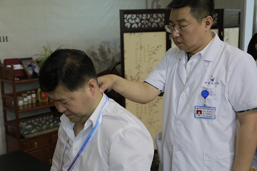 我校附属第一医院治未病中心王先滨为参展商做手法按摩